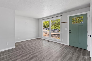 Foyer entrance with a textured ceiling and wood finished floors