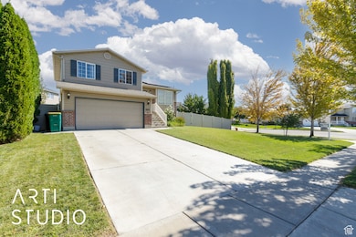 Traditional-style house featuring brick siding, driveway, and an attached garage