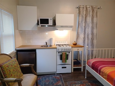 Kitchen with white appliances, a sink, under cabi