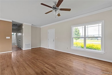Spare room featuring ornamental molding, wood fini
