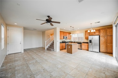 Kitchen with stainless steel appliances, a chandel