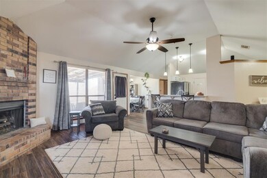 Living room with a brick fireplace, vaulted ceilin