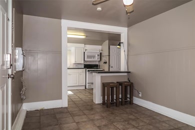 Kitchen with white appliances, dark countertops, 