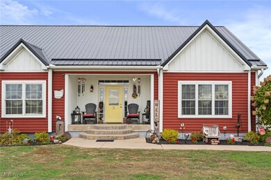 Modern inspired farmhouse with a porch, board and batten siding, a front lawn, and a metal roof