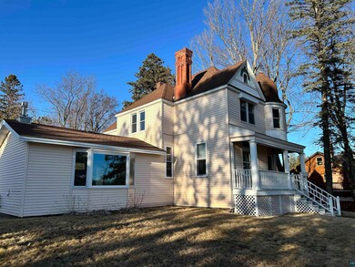 Rear view of house with a lawn, covered porch, and