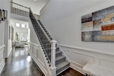 Stairs featuring a decorative wall, wainscoting, and wood finished floors