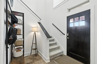 Foyer entrance with stairway and wood finished fl