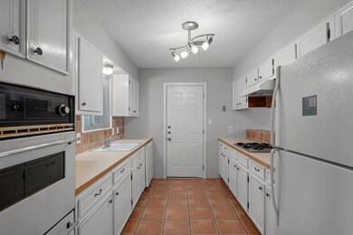 Kitchen featuring white appliances, a sink, white