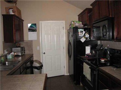 Kitchen. Tiled counter tops, smooth top stove and 