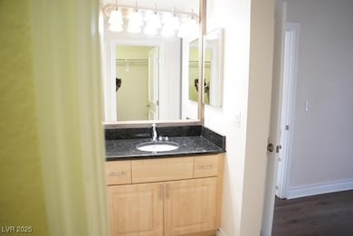 Bathroom featuring vanity, baseboards, and wood fi