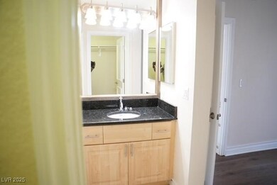 Bathroom featuring vanity, baseboards, and wood fi