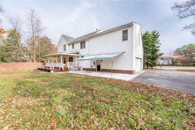 Back of property with a lawn and a garage