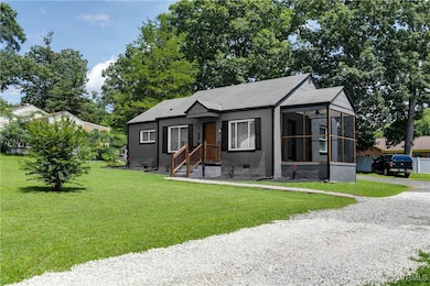 Bungalow with a sunroom, driveway, and a front yar