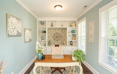 Home office with visible vents, crown molding, bas