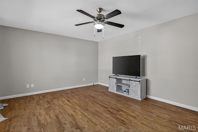 Unfurnished living room with dark wood finished floors and a ceiling fan