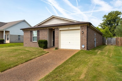Ranch-style home featuring a front yard and a gara