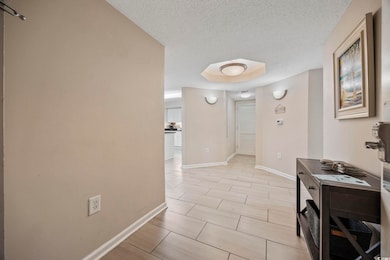 Hallway featuring a textured ceiling and wood finish floors