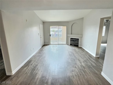 Unfurnished living room featuring baseboards, a gl