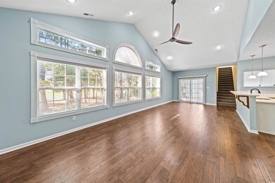 Unfurnished living room with ceiling fan, sink, dark wood-type flooring, and high vaulted ceiling