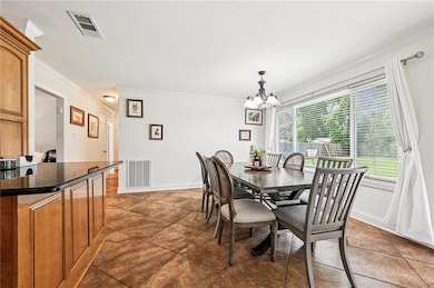 Spacious and sunlit dining area with oversized windows overlooking the backyard- perfect for quality time and entertaining. Features tile flooring and easy access to the kitchen.