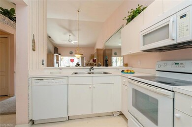 Kitchen with white appliances, ceiling fan, sink, 
