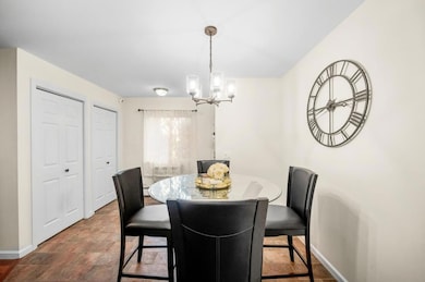 Dining space featuring a chandelier and stone finish floors