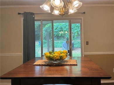 Dining space featuring a chandelier and crown molding