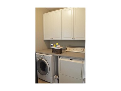 Main floor laundry with custom countertop and uppe