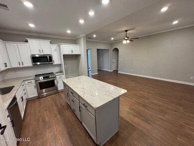 Kitchen with backsplash, light stone counters, dar
