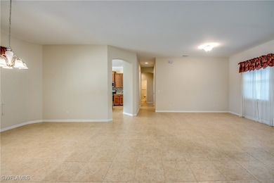 Unfurnished room featuring arched walkways, a chan