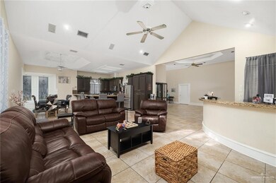 Tiled living room with high vaulted ceiling and ceiling fan