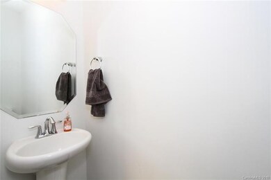 Main floor half bath with pedestal sink and commod