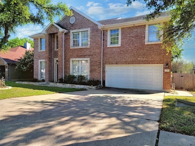 Colonial house with brick siding, driveway, fence