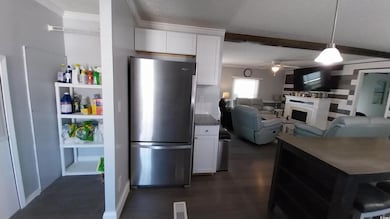 Kitchen with freestanding refrigerator, white cabi
