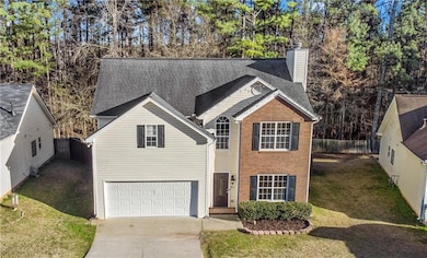 Traditional-style home featuring a garage, a chimn