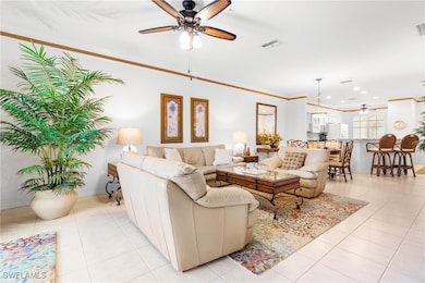 Living room featuring crown molding, ceiling fan,