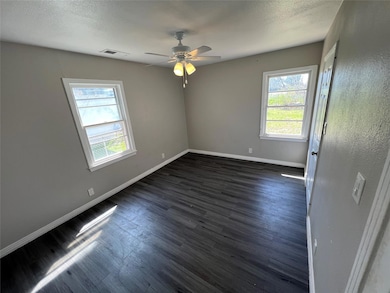 Spare room featuring dark wood-style flooring, bas