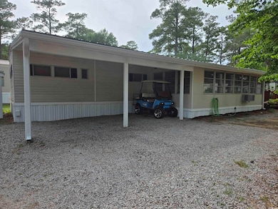 View of side of property featuring an attached carport and driveway