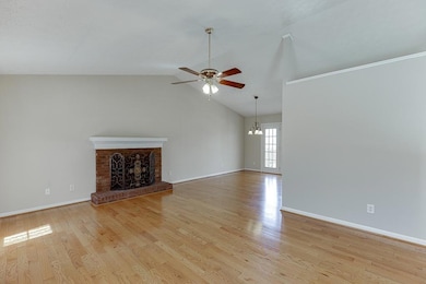 Unfurnished living room featuring baseboards, a fi