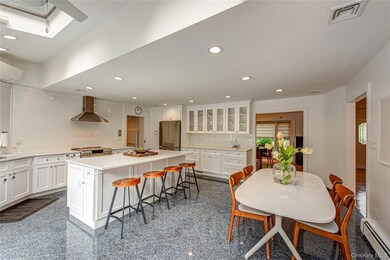 Kitchen featuring tasteful backsplash, granite floors, center island, recessed lighting, and white cabinetry