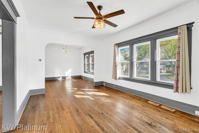 Unfurnished room with wood finished floors, arched walkways, and a ceiling fan
