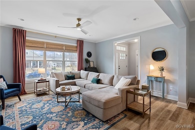 Living area featuring baseboards, crown molding, a