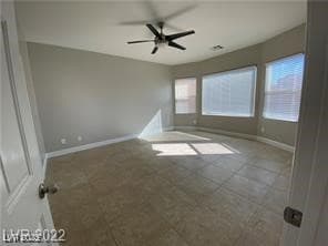 Unfurnished room featuring a ceiling fan and baseb