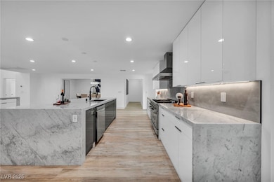 Kitchen featuring modern cabinets, wall chimney ra
