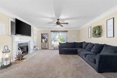 Large living room with ceiling fan, crown molding 
