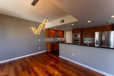 Kitchen featuring appliances with stainless steel finishes, recessed lighting, dark wood finished floors, backsplash, and hanging light fixtures