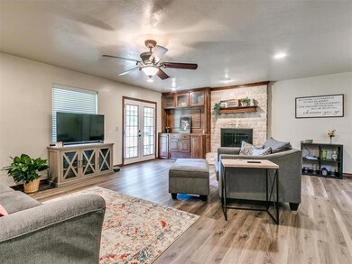 Open living room with wood burning fireplace and p