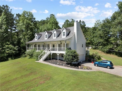 Cape cod-style house with a porch, stairs, a front lawn, and a chimney