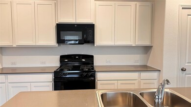 Kitchen featuring black appliances, a sink, and w