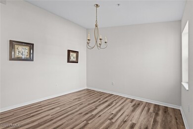 Spare room with wood finished floors, a chandelier